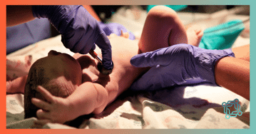 A new born baby being checked for an injury 
