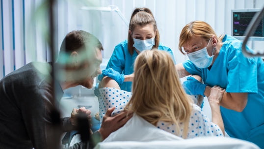 doctor pulling a baby through the birth canal