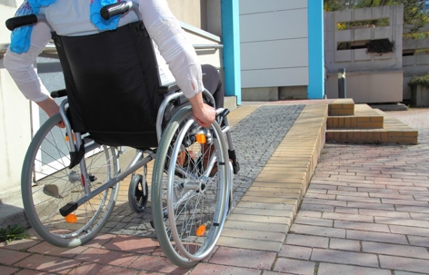 man in a wheel chair going up a ramp